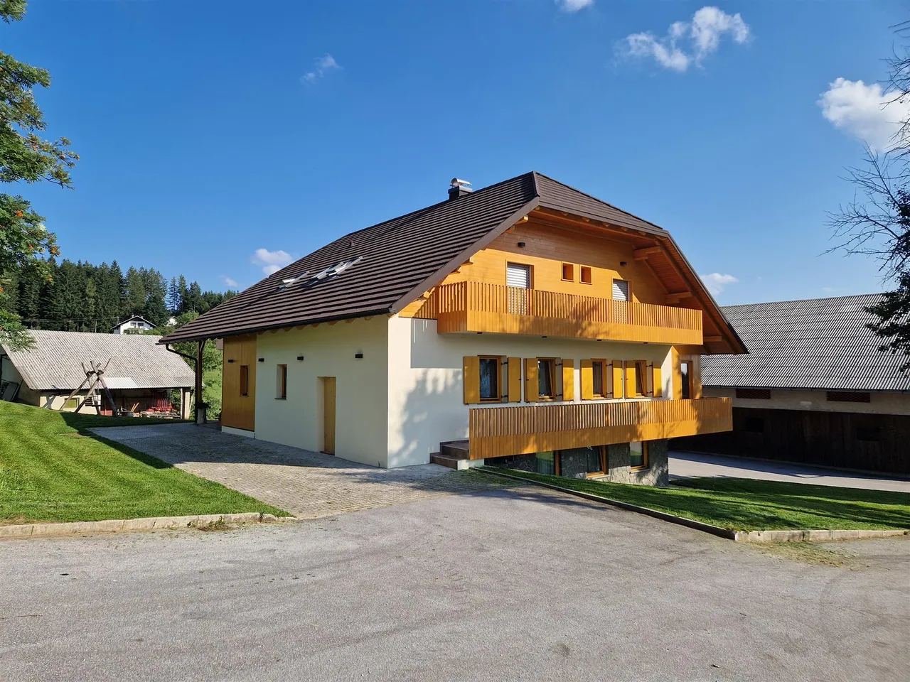 Turistična kmetija Ramšak poleti, lesena hiša z balkoni