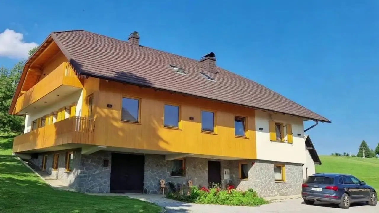 Lesena hiša turistične kmetije Ramšak na travniku